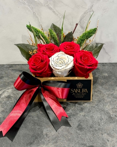 4 red and 1 white gold preserved roses in a wooden bamboo box