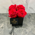 4 red preserved roses in a glass black pot